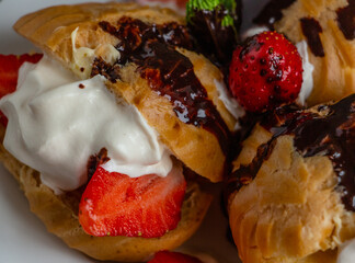  delicious eclairs with ice cream and strawberries, topped with chocolate glaze - the perfect dessert, macro photography