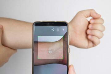 A man reads data using a special device from an implanted chip in a man's hand. Future technology concept and human chipping. Electronic documents and biotechnology
