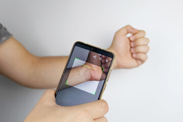 A man reads data using a special device from an implanted chip in a man's hand. Future technology concept and human chipping. Electronic documents and biotechnology