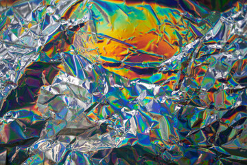 Fototapeta premium Glued colorful holographic background. Modern Rainbow foil for Texture, cover, wallpaper, print, dll. Dark futuristic blurred hologram and Abstract gradient colors. 