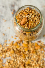 oatmeal or granola with almonds and hazelnut for nutritious breakfast on white marble background