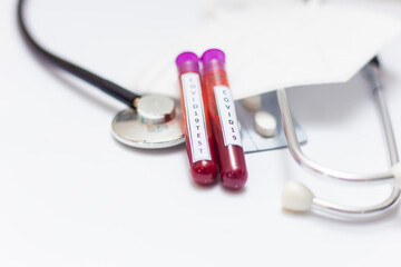Microbiologist with a tube of biological blood sample contaminated by Coronavirus with label Covid-19