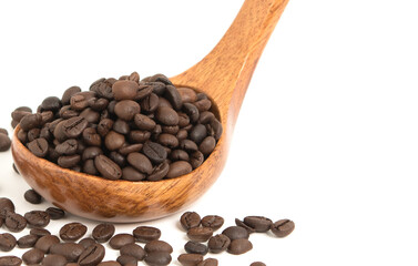 Coffee beans are strewed in a spoon wood for coffee on a white background