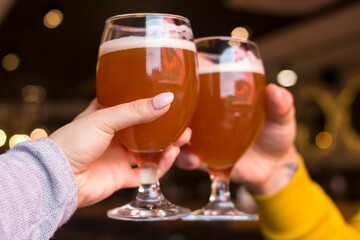 Boy and girl clink glasses of beer