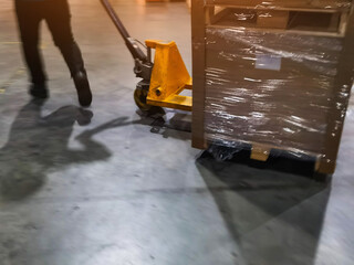 Worker driving forklift loading shipment carton boxes goods on wooden pallet at loading dock from container truck to warehouse cargo storage in freight logistics, transportation industrial, delivery © Weerayuth