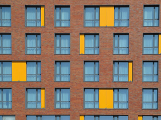 Fototapeta na wymiar Abstract brown and yellow brick facade with windows