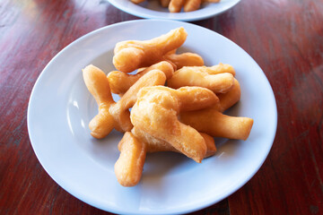 Chinese bread stick or chinese donut on dish. Breakfast street food usually eat with hot tea, coffee or soy milk.