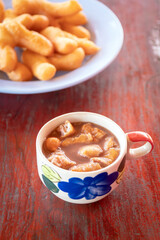 Chinese bread stick or chinese donut in hot coffee. Breakfast street food usually eat with hot tea, coffee or soy milk.