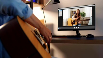 music, e-learning and technology concept - young man or musician with computer learning to play guitar with teacher online at home
