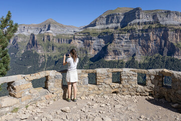 Scenic viewpoint over Ordesa Valley with turist girl on it. Ordesa y Monte Perdido National Park. Huesca, Aragon, Spain.