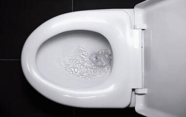 The white flush toilet bowl that the water is draining. concept of flushing away something. - obrazy, fototapety, plakaty