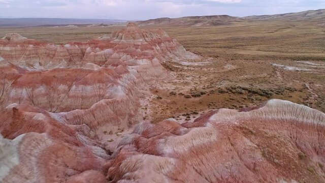 Flying up and over red desert hills to get aerial view of the Wyoming landscape.