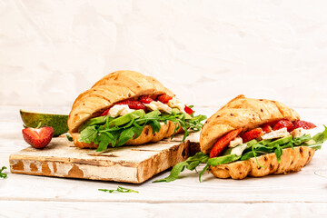 Food recipe background. Close up Breakfast, business lunch, sandwiches Croissant with strawberries and soft cheese with mold brie camembert. banner menu recipe top view