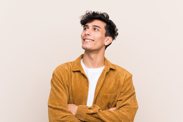 Fototapeta premium Young Argentinian man over isolated background looking up while smiling