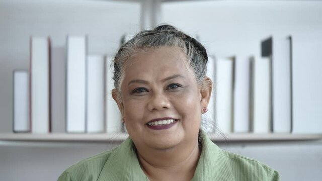 Smiling Asian elderly woman face close up happy in the room of the house. Grandma or grandmother smiling with healthy teeth. International Day of Older Persons. Concept of health care for senile