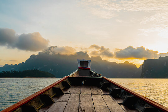 View from a wooden Thai style boat in dam with white big stonds. There are many limestones in the early morning with sunrise. Feeling fresh and relax. Ideas for traveling background with copy space.