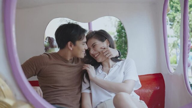 Asian couple love men and women happy summer travel activities. Tourists enjoy the rides in the amusement park. Concept Tourism business