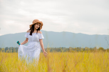 Fototapeta na wymiar Portrait of asian woman in white dress with guitar ukulele enjoying life on meadow at park