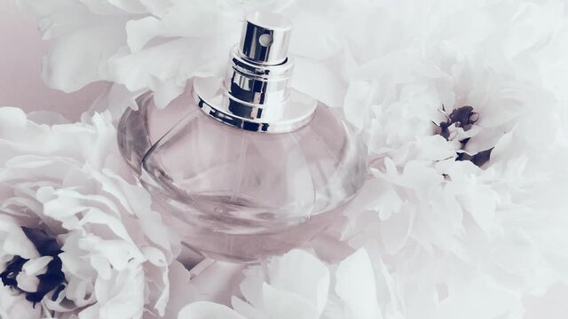 White perfume bottle with peony flowers, chic fragrance scent as luxury cosmetic, fashion and beauty product background, stock footage