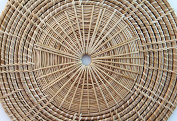 Close-up view of basketry plate isolated on a white background.