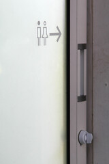 Toilet sign on aluminum slide door.
