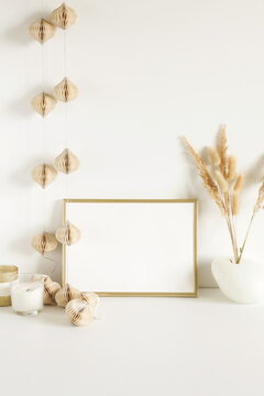 Photo frame mock up, fluffy reeds bouquet in a vase, interiour accessories near the white wall. Copy space template. Minimalist scandinavian interior design . © irenastar