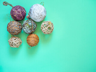 Christmas ornaments balls isolated on green. Rustic and artful xmas decoration handmade for hanging on the christmas tree. Holidays and tradition concept. Copy space.