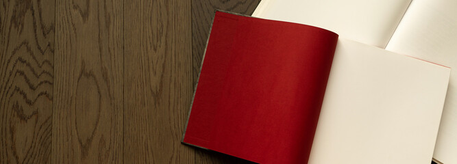 Open book on wooden table with red and white empty pages. Booklet, magazine mock up for any design or advertising 