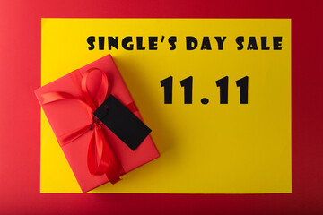11.11 single's day sale concept. Online shopping concept. Red gift with Black tag paper on yellow and red background with copy space
