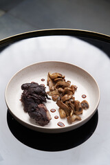 Baked lamb chops and mushrooms on a white plate.