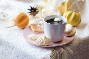 A cup of coffee, meringues, pumpkins, leaves, a warm blanket on the windowsill, the concept of home comfort, relaxation, loneliness, Thanksgiving, autumn season