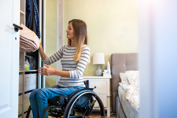 Woman in wheelchair sorts through her wardrobe
