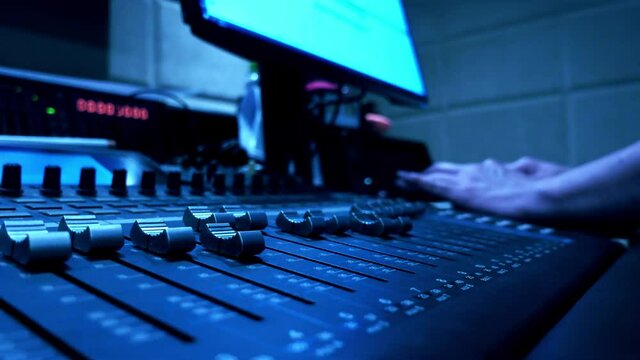 Sound engineer working in the sound studio on audio mixing machine 16 tracks with the computer for sound balance software. 4K