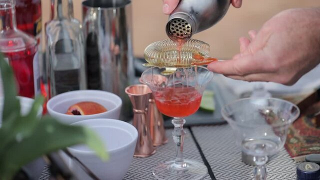 Outdoor bar with a cocktail being poured into a crystal glass on a spring themed table