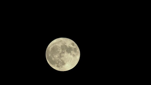 The full moon rises and crosses the frame in this lunar time lapse