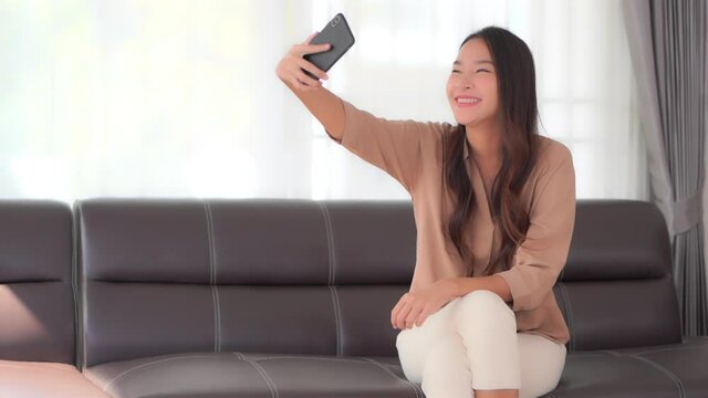 Happy Attractive Asian Female Making Video Call With Her Smartphone. Social Networking Concept, Static Full Frame