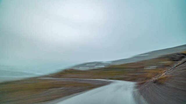 A drive on the County Road 258 towards Stryn, Norway. Thin fog hanging in the air. Patches of snow cover the rusty landscape here and there. It is gloomy and cold.