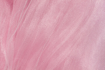 Pink tulle fabric texture top view. Coral background. Fashion color trends feminine tutu skirt flat lay, female blog backdrop for text signs desidgn. Girly abstract wallpaper, textile surface.