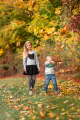 Happy little kids with autumn leaves in the park