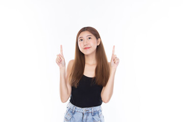 Fashion of a beautiful young asian woman in a pretty black vest and blue jeans feeling smile and happy. Girl pointing up with index finger to copy space isolated on white background. 