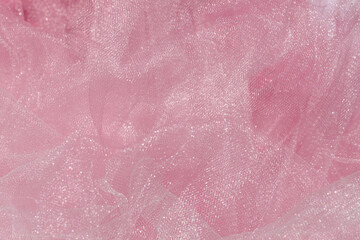 Fototapeta premium Pink tulle fabric texture top view. Coral background. Fashion color trends feminine tutu skirt flat lay, female blog backdrop for text signs desidgn. Girly abstract wallpaper, textile surface.