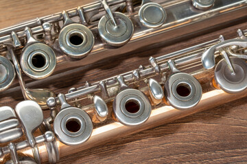 Gloden flute and silver flute close up on a brown wooden background