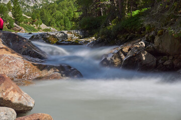 Langzeitbelichtung eines Wasserlaufs &uuml;ber Steine in den Bergen mit seidenem Wasser