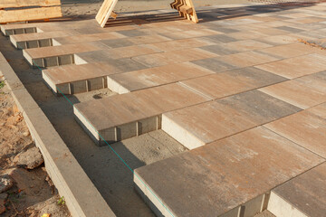 Using a stretched cord to level the paving slabs.