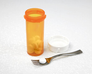 Diet pill concept - pill and fork with pill bottle on white surface 