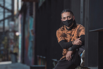 Obraz na płótnie Canvas Mexican Latin young manl, urban portrait wearing black face mask