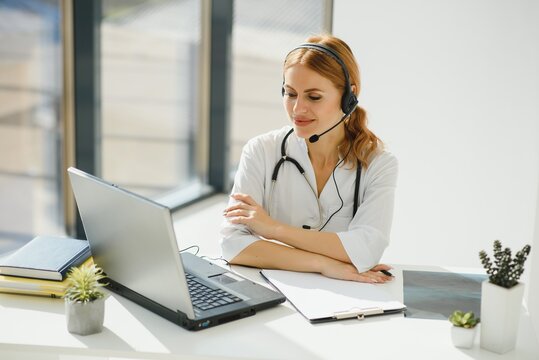 Doctor Talking With Sick Person Through Laptop Online System And Using Mobile Digital Tablet Computer Searching Patient Medical Records On The Database Files Document.
