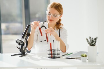 Scientist using a microscope in a laboratory, Testing for Coronavirus Covid19 vaccine