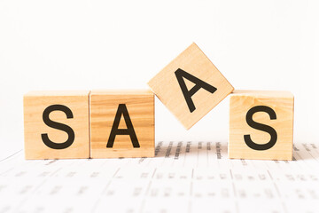 Word saas. Wooden small cubes with letters isolated on white background with copy space available.Business Concept image.