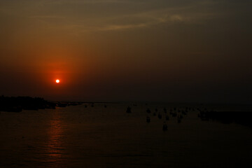 The sunset at a lovely beach crowded by peoples & animals